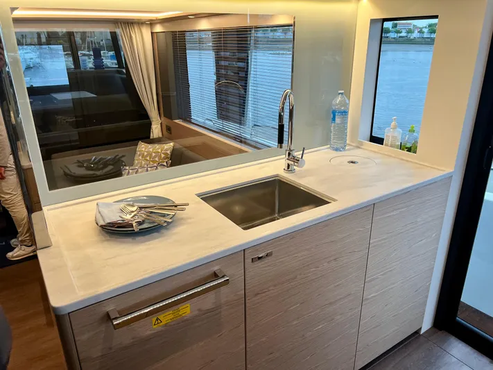 Yacht Photos Pics Modern kitchen area in 2025 Beneteau Swift Trawler 54 yacht with sink and window view.