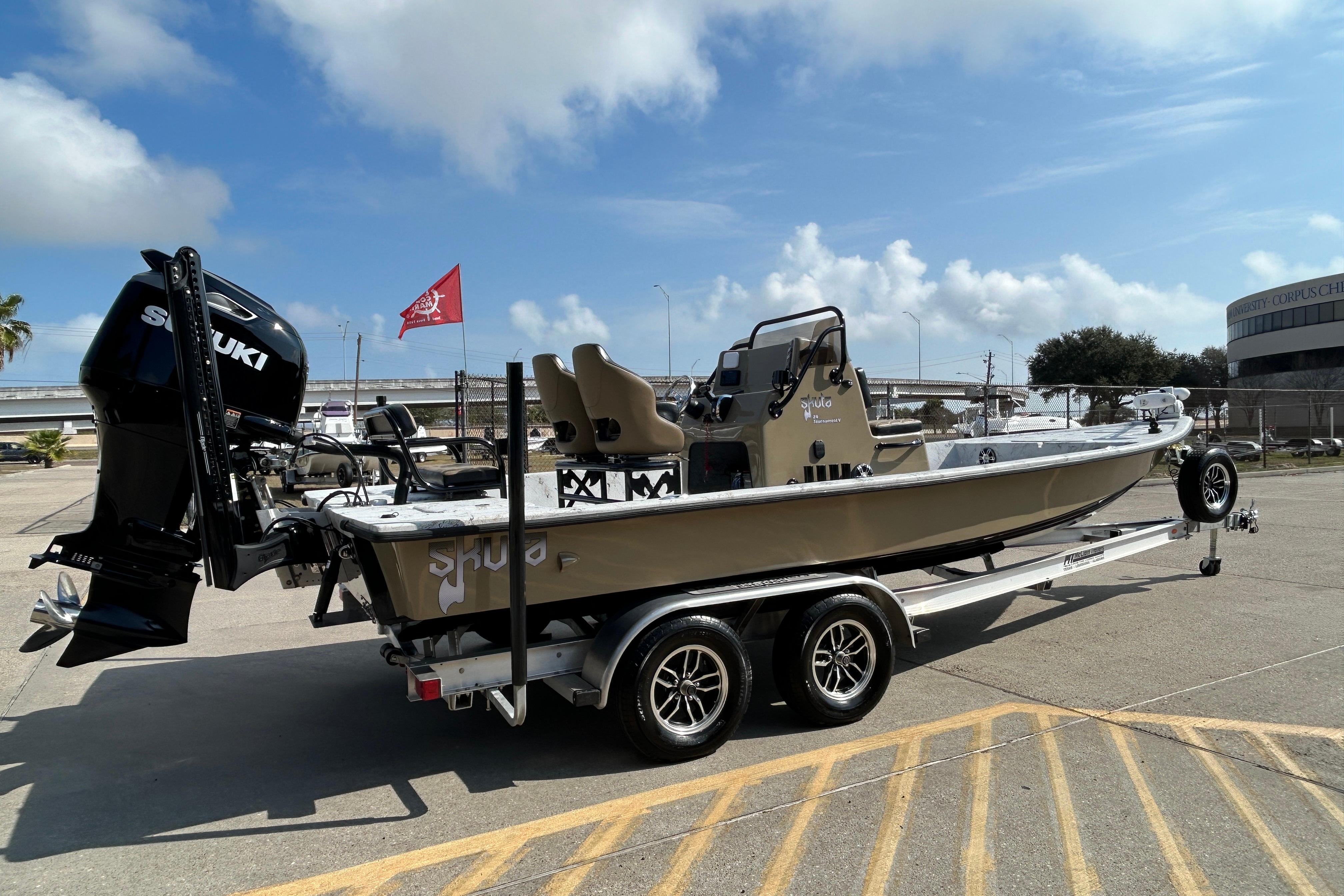 2026 Skuta 24 Vista boat on trailer with Suzuki engine, parked outdoors.