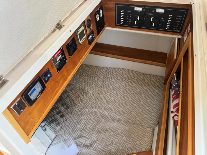  Yacht Photos Pics 2021 Cutwater C-32 CB cabin interior with control panels and patterned bedding.