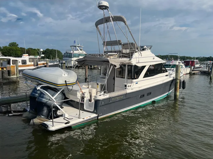  Yacht Photos Pics 2021 Cutwater C-32 CB boat docked at marina, featuring inflatable dinghy and outboard motor.