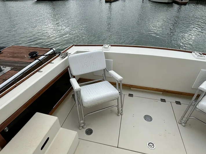 Gullywhumper Yacht Photos Pics 2001 Ellis 36 Flybridge boat deck with white chairs by the water.