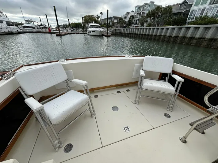 Gullywhumper Yacht Photos Pics Two white chairs on the deck of a 2001 Ellis 36 Flybridge boat.