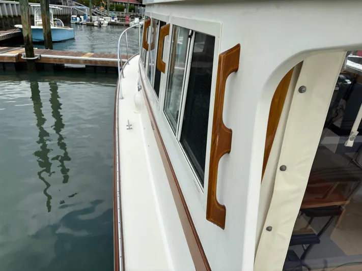 Gullywhumper Yacht Photos Pics 2001 Ellis 36 Flybridge yacht docked, showcasing side view with wooden accents and windows.