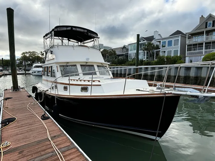 Gullywhumper Yacht Photos Pics Ellis 36 Flybridge 2001 yacht docked at marina, overcast sky, waterfront homes in background.