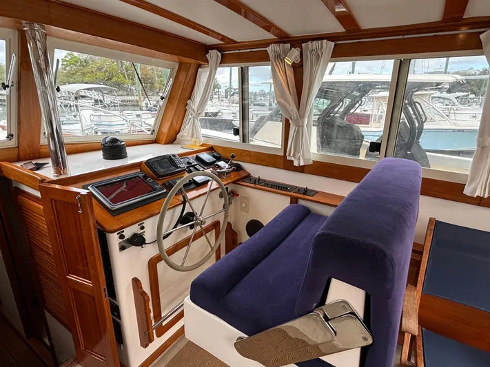 Gullywhumper Yacht Photos Pics 2001 Ellis 36 Flybridge helm with wooden accents and blue seating, overlooking marina.