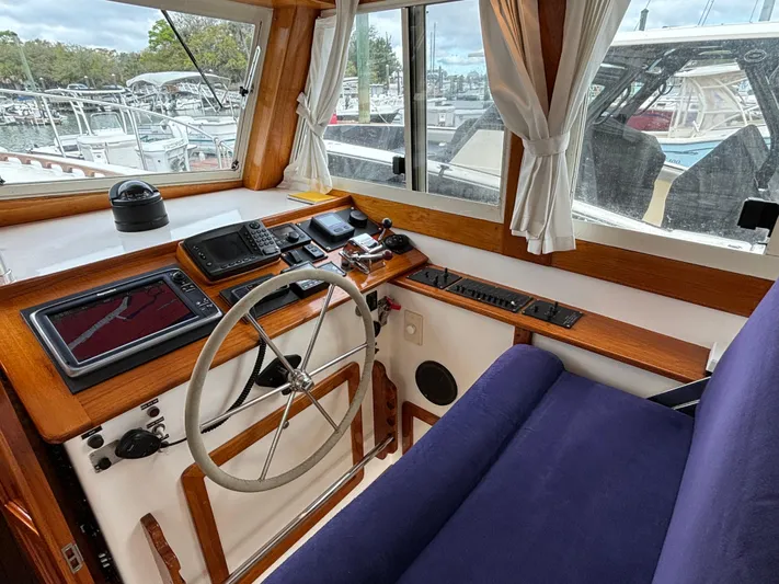 Gullywhumper Yacht Photos Pics Helm of 2001 Ellis 36 Flybridge with navigation equipment and blue seating.