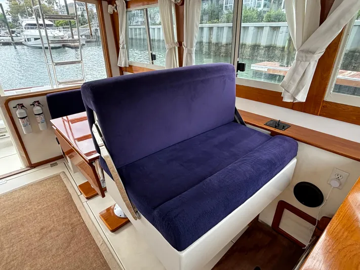 Gullywhumper Yacht Photos Pics Interior of 2001 Ellis 36 Flybridge with blue seating and wooden accents, overlooking marina.