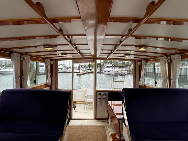 Gullywhumper Yacht Photos Pics Interior view of 2001 Ellis 36 Flybridge yacht with wooden accents and marina backdrop.