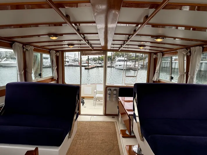 Gullywhumper Yacht Photos Pics Interior view of 2001 Ellis 36 Flybridge yacht with blue seating and wooden accents.