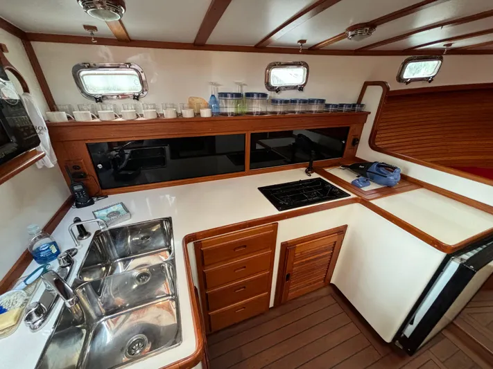 Gullywhumper Yacht Photos Pics 2001 Ellis 36 Flybridge yacht kitchen with dual sinks, stove, and wooden cabinetry.
