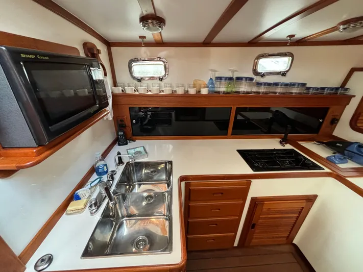 Gullywhumper Yacht Photos Pics Galley kitchen in 2001 Ellis 36 Flybridge boat with sink, stove, and microwave.