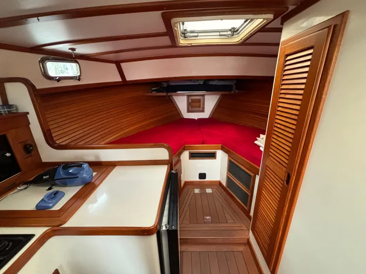Gullywhumper Yacht Photos Pics Interior of 2001 Ellis 36 Flybridge boat with wood paneling and red bedding.