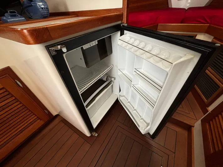 Gullywhumper Yacht Photos Pics Open refrigerator inside 2001 Ellis 36 Flybridge boat, featuring wooden interior and red seating.