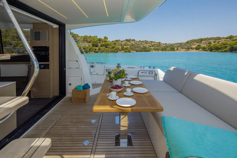  Yacht Photos Pics Luxurious 2022 Prestige 520 yacht with elegant dining area overlooking serene blue waters.