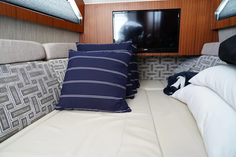 Yacht Photos Pics Luxurious interior of 2022 Pursuit 428 yacht with cozy bedding and modern TV.