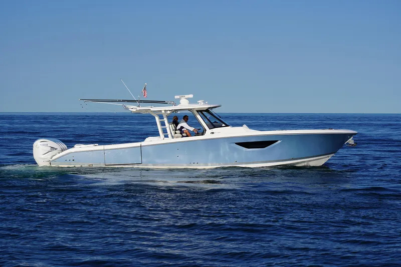  Yacht Photos Pics 2022 Pursuit 428 boat cruising on open water under clear blue sky.
