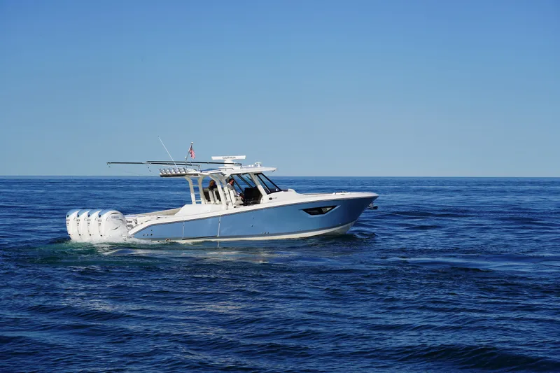  Yacht Photos Pics 2022 Pursuit 428 boat cruising on open ocean under clear blue sky.
