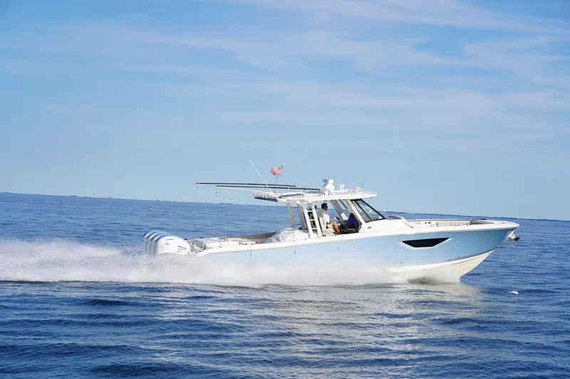  Yacht Photos Pics 2022 Pursuit 428 boat cruising on open water under clear blue sky.