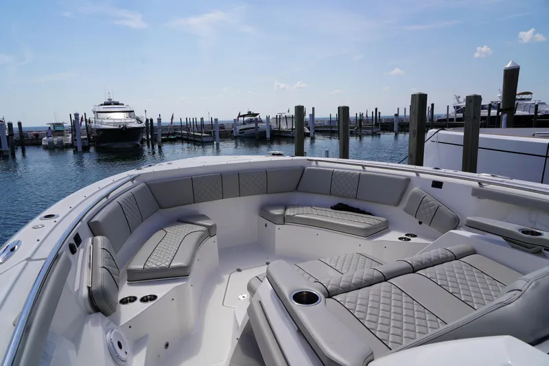  Yacht Photos Pics Luxurious 2022 Pursuit 428 boat interior with plush seating at a marina.