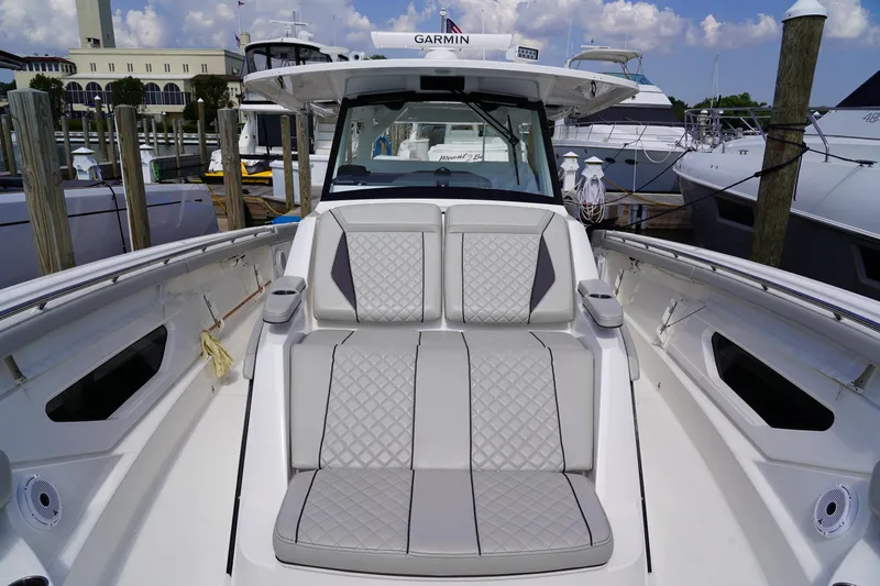  Yacht Photos Pics Luxurious 2022 Pursuit 428 boat with plush seating at a marina.