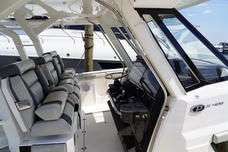  Yacht Photos Pics 2022 Pursuit 428 boat interior with luxurious seating and modern dashboard.