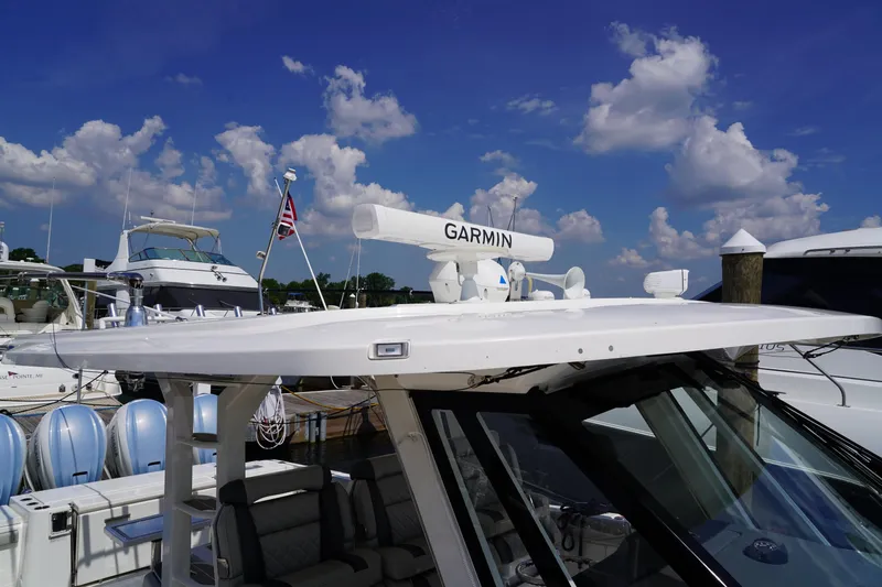  Yacht Photos Pics 2022 Pursuit 428 boat with Garmin radar, docked under a blue sky.