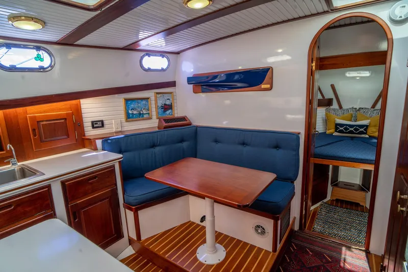 Irish Ayes Yacht Photos Pics Cozy interior of 1993 Atlantic Duffy 48 yacht with blue seating and wooden accents.