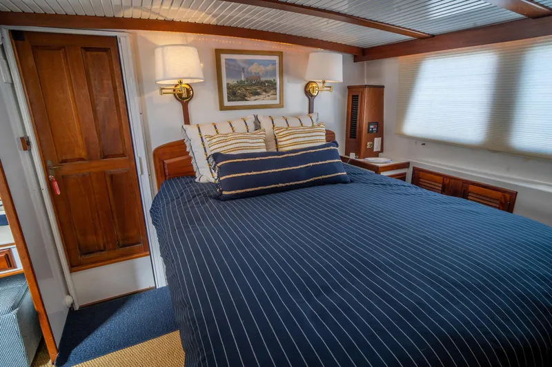 Irish Ayes Yacht Photos Pics Cozy bedroom interior of 1993 Atlantic Duffy 48 yacht with striped bedding and wooden accents.