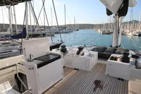 Luxurious Lagoon 620 yacht deck with modern amenities, docked in a serene marina.