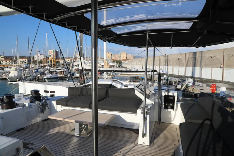  Yacht Photos Pics Lagoon 620 yacht deck with seating area, docked at marina, 2020 model.