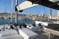 Lagoon 620 catamaran deck, 2020 model, docked in a marina with multiple sailboats.