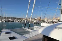 2020 Lagoon 620 catamaran docked in a marina with clear blue skies.
