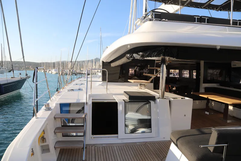  Yacht Photos Pics Luxurious 2020 Lagoon 620 yacht deck with seating, docked in a marina.