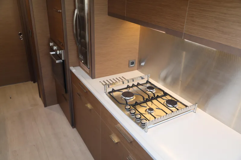  Yacht Photos Pics Modern kitchen interior of 2020 Lagoon 620 yacht with sleek wooden cabinetry and gas stove.