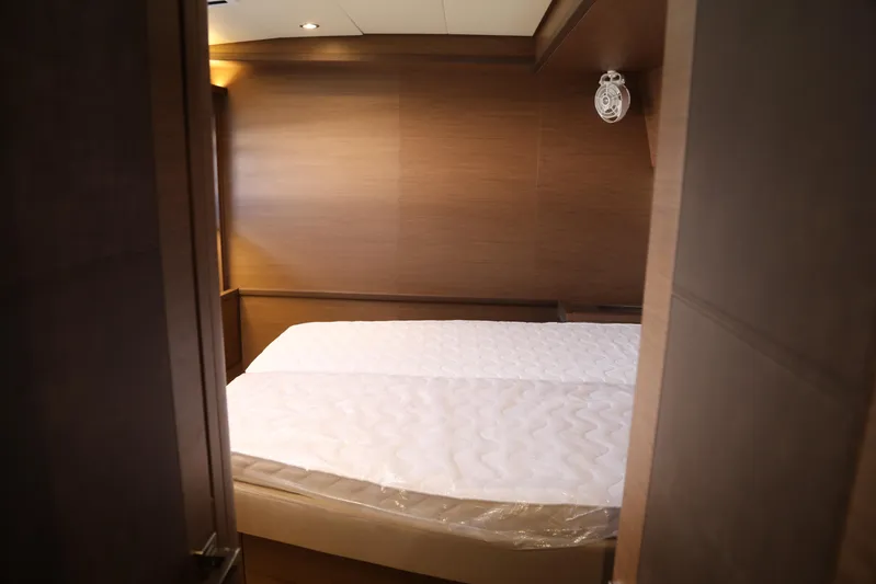  Yacht Photos Pics 2020 Lagoon 620 yacht cabin with a cozy bed and wooden interior.