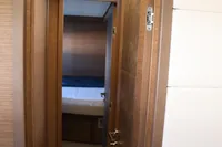 Interior view of Lagoon 620 yacht, featuring a wooden door and modern design elements.