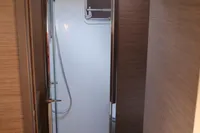 2020 Lagoon 620 yacht bathroom with shower, wooden accents, and modern fixtures.