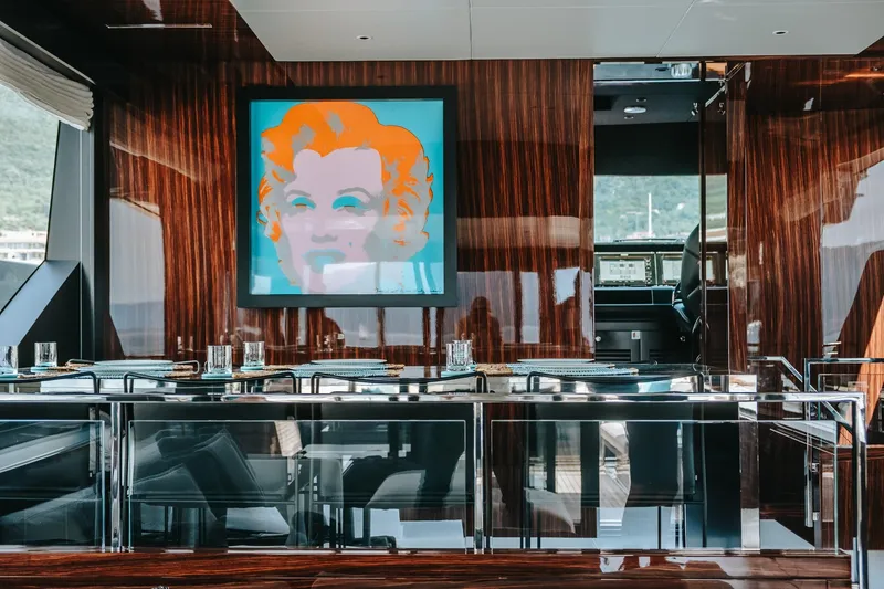 4990 Yacht Photos Pics Luxurious interior of 2024 Riva 82' Diva yacht with modern art and elegant dining setup.