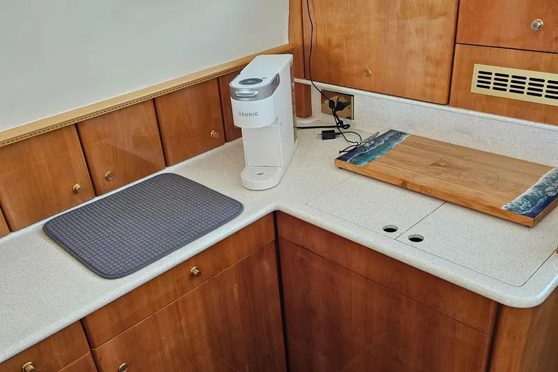 My Girls Too Yacht Photos Pics Kitchen area of 1998 Viking Princess 460 Sport Cruiser Flybridge with appliances and wooden cabinetry.