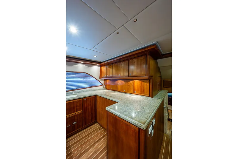  Yacht Photos Pics Luxurious 2006 Bertram 630 Convertible yacht interior with elegant wood cabinetry and granite countertops.
