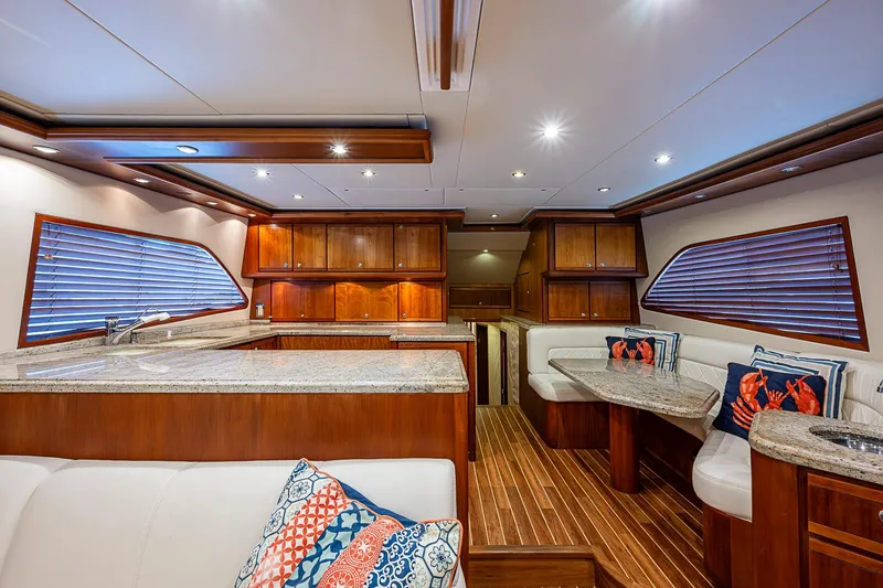  Yacht Photos Pics Luxurious interior of 2006 Bertram 630 Convertible yacht with wood finishes and plush seating.