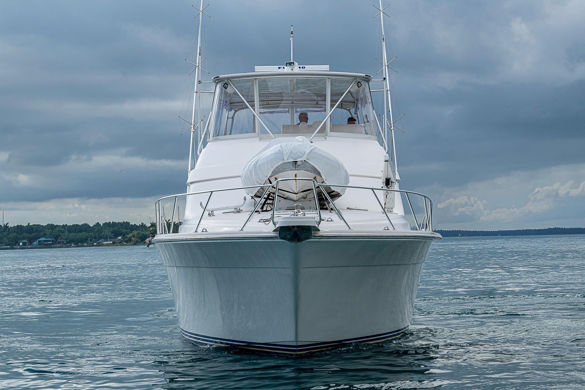 2006 Bertram 630 Convertible yacht on calm waters under cloudy skies.