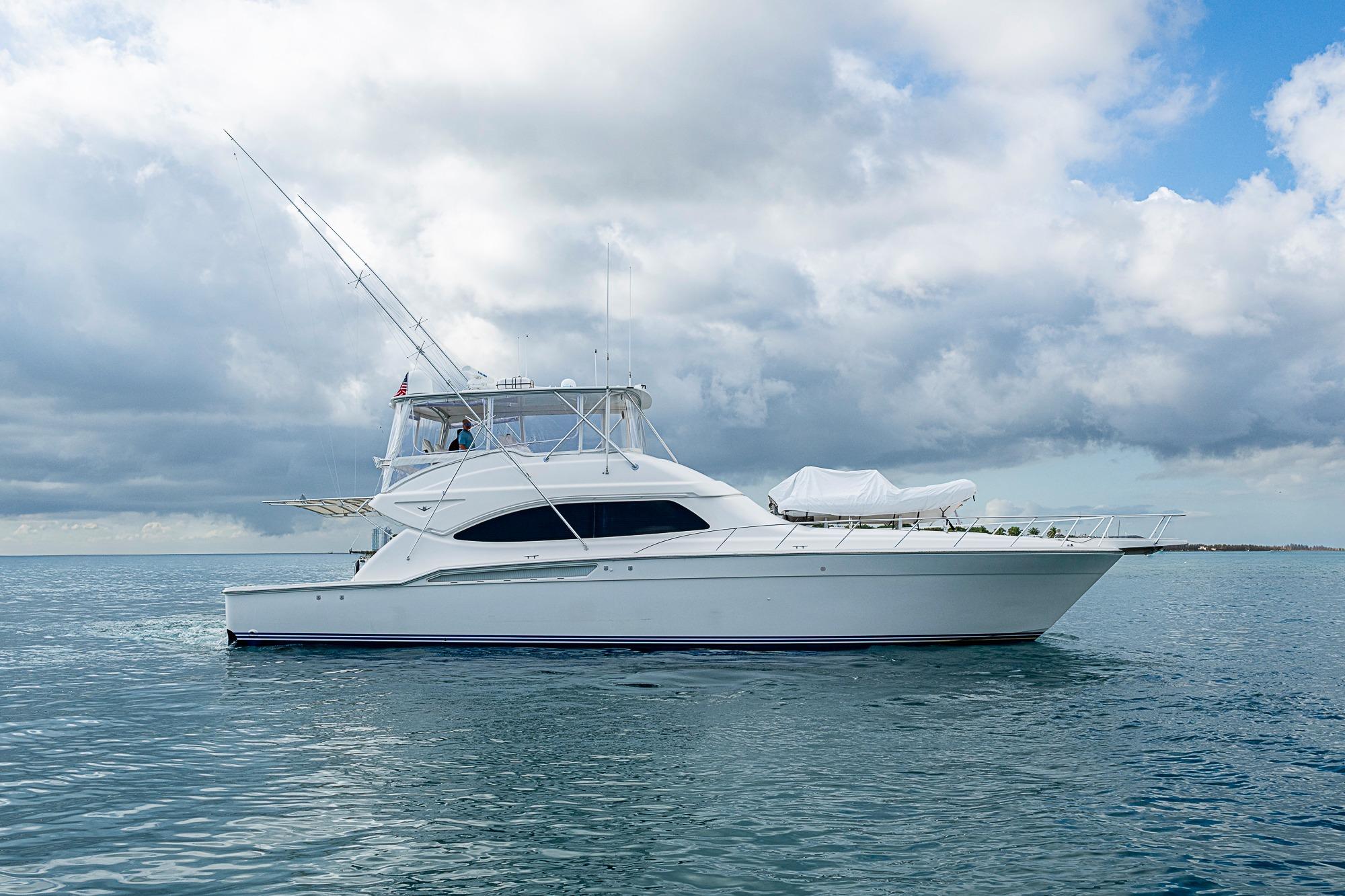 2006 Bertram 630 Convertible yacht on calm ocean under cloudy sky.