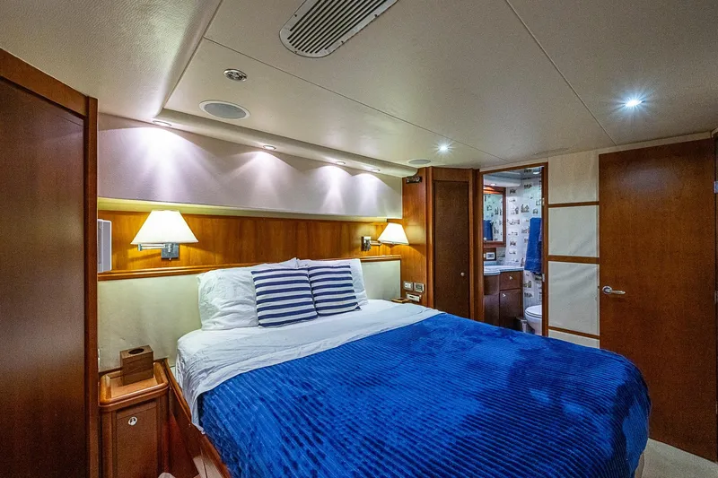  Yacht Photos Pics Luxurious bedroom interior of 2006 Bertram 630 Convertible yacht with blue bedding.