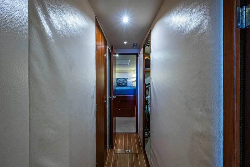  Yacht Photos Pics Interior hallway of 2006 Bertram 630 Convertible yacht, featuring wood paneling and modern lighting.