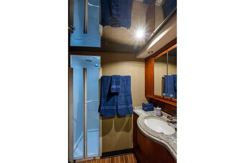  Yacht Photos Pics Luxurious bathroom in 2006 Bertram 630 Convertible yacht with modern fixtures and blue towels.