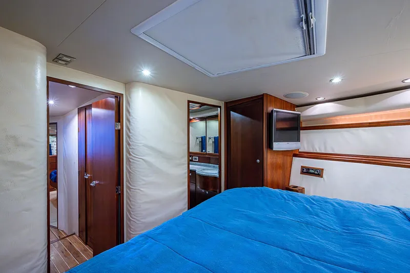  Yacht Photos Pics Luxurious interior of 2006 Bertram 630 Convertible yacht with blue bedding and wood accents.