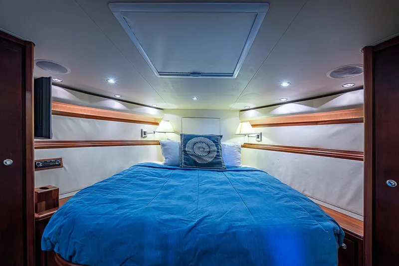  Yacht Photos Pics Luxurious cabin interior of 2006 Bertram 630 Convertible yacht with blue bedding.
