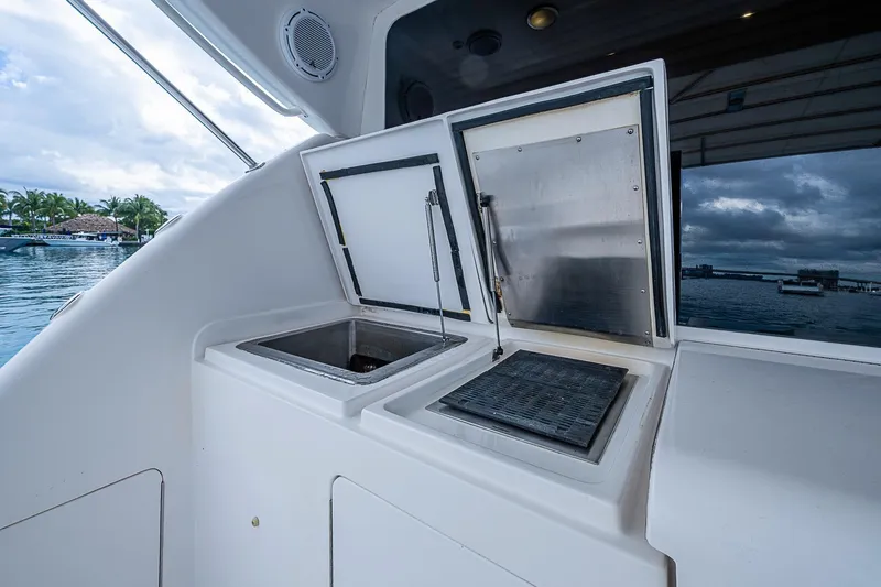  Yacht Photos Pics 2006 Bertram 630 Convertible yacht with open storage compartments, dockside view.