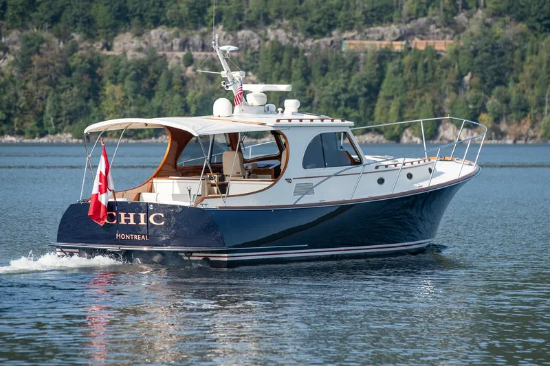 Chic Yacht Photos Pics 2003 Hinckley Talaria 44 Express yacht cruising on a scenic lake.